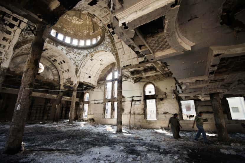 Coptic Christians walk amid debris inside Amba Moussa Coptic church in Minya.