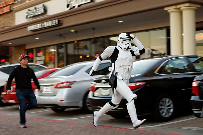  Taylor Wren, dressed as a Stormtrooper, raced across a strip shopping center parking lot as...