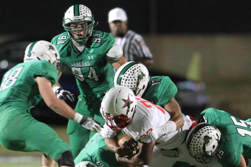 Coppell running back Brandon Rice (22) is stopped by Southlake Carroll defenders Andy Chelf...