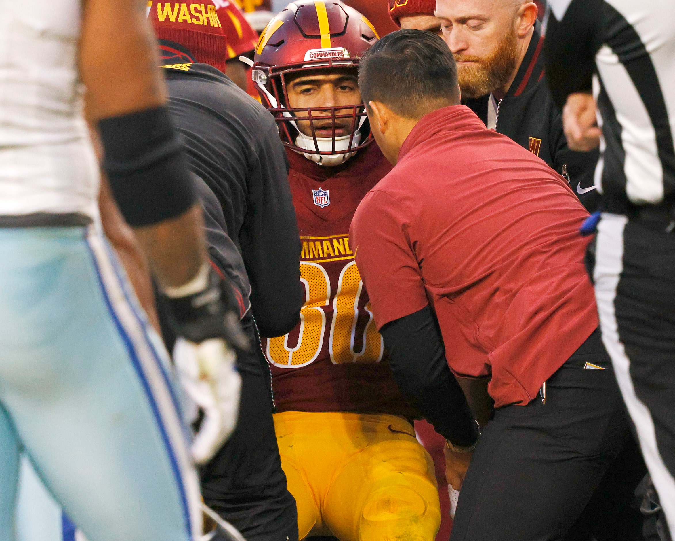 Washington Commanders running back Austin Ekeler (30) is helped to leave a field after...