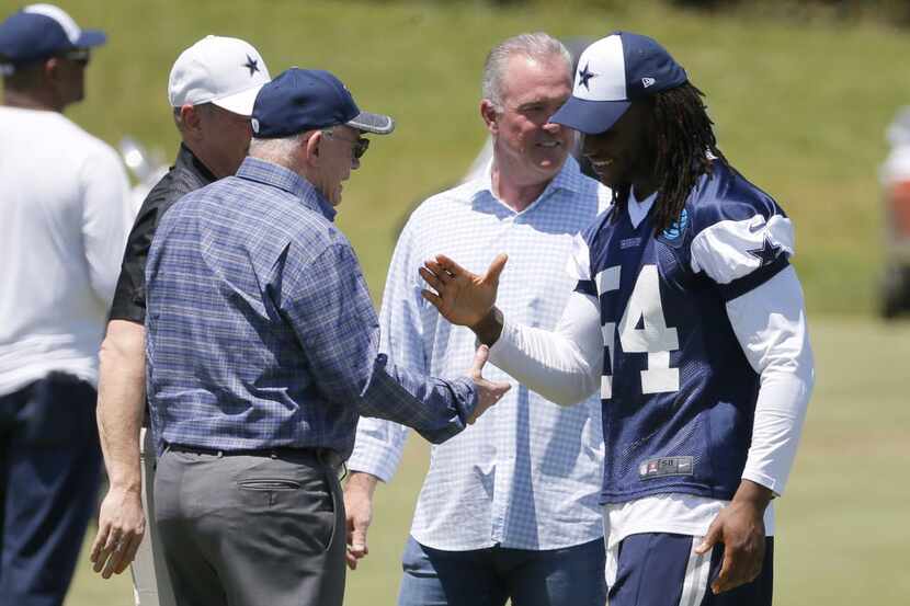 Dallas Cowboys team owner Jerry Jones, front left, shakes hands with linebacker Jaylon...