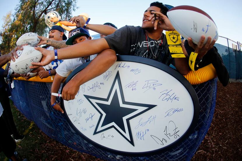 Fans crowd in to get an autograph from former Dallas Cowboys Hall of Fame receiver Michael...