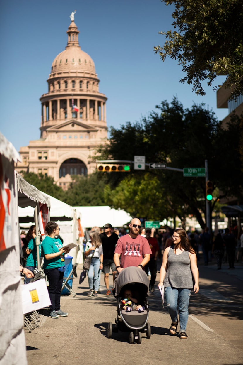 Aaron Niner and his wife Mallaree Niner walk down Congress Avenue with their son, Liam...