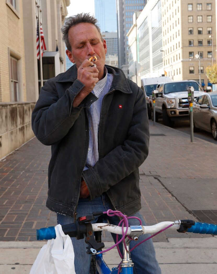 Sean Baugh lights a cigarette as he talks about his dog Lamb of God after a hearing at...