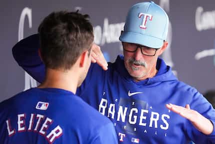 Texas Rangers pitcher Jack Leiter talks with pitching coach Mike Maddux in the dugout during...
