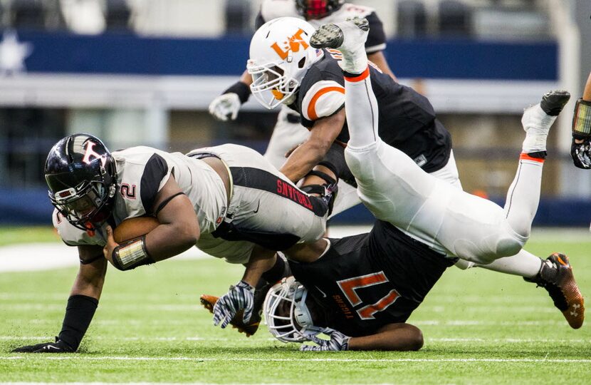 Euless Trinity quarterback Tyler Natee (2) is tackled by Lancaster linebacker Trevon Brooks...