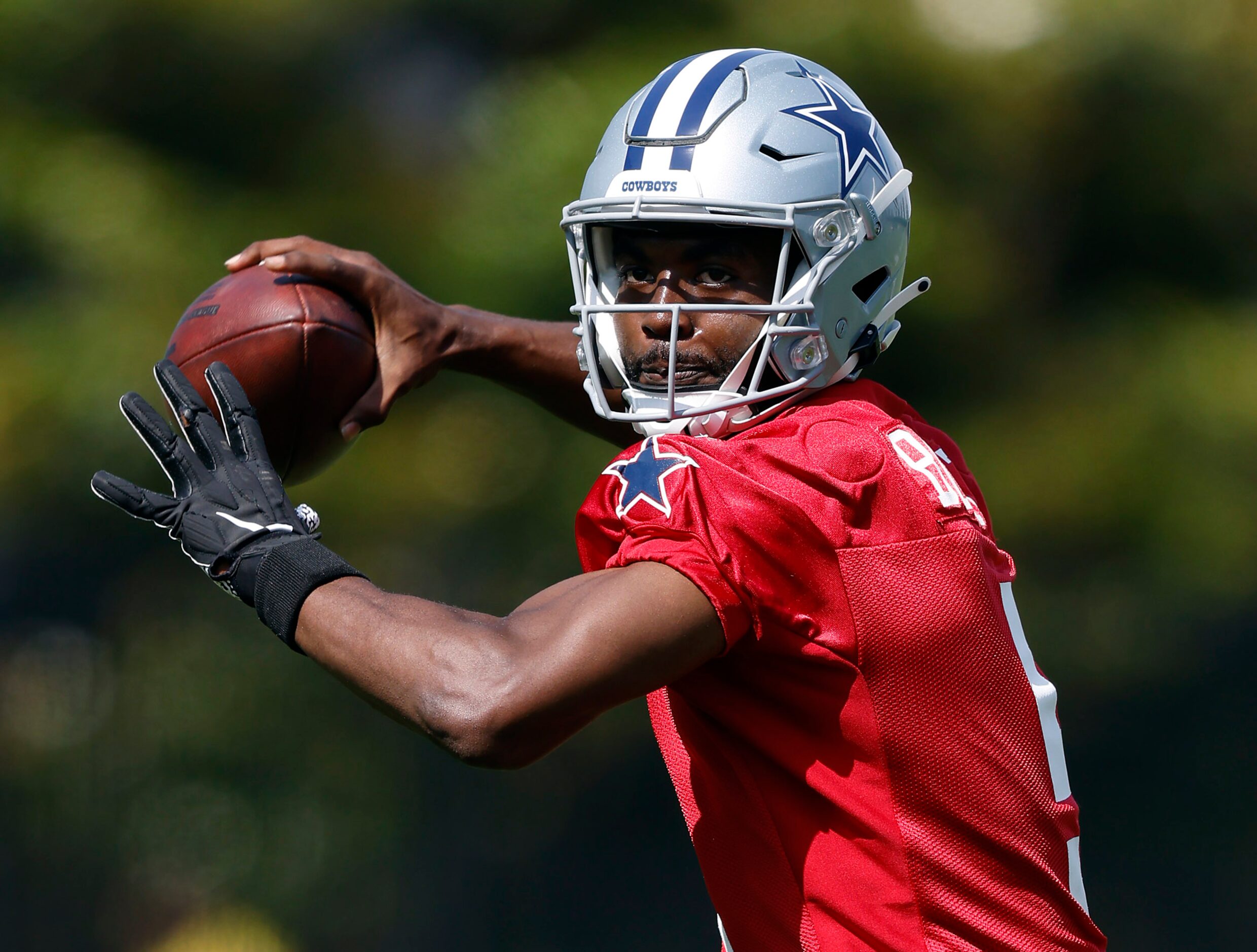 Dallas Cowboys quarterback JT Barrett (5) throws on the run during rookie minicamp at the...