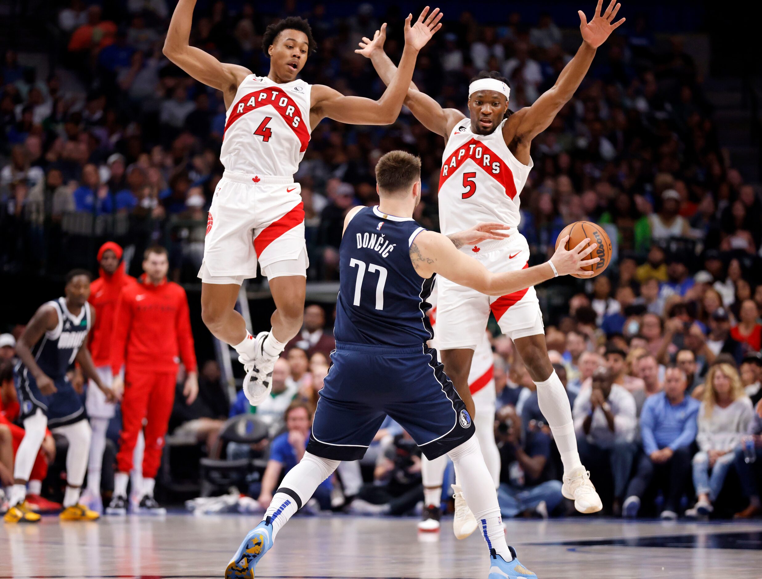 Dallas Mavericks guard Luka Doncic (77) is double teamed by Toronto Raptors forward Scottie...