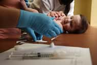 Henry Marr looks over before getting a shot during a medical appointment on Tuesday, January...