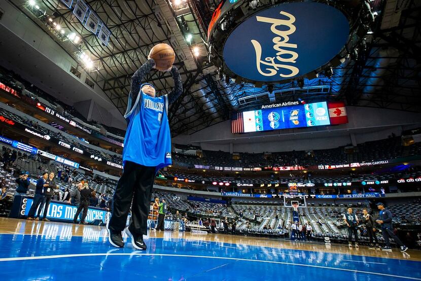 Rutger McCrum shoots baskets on the court before an NBA basketball game between the Dallas...
