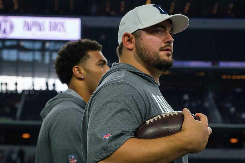 Dallas Cowboys offensive guard Zack Martin watches his teammates warm up before an NFL...