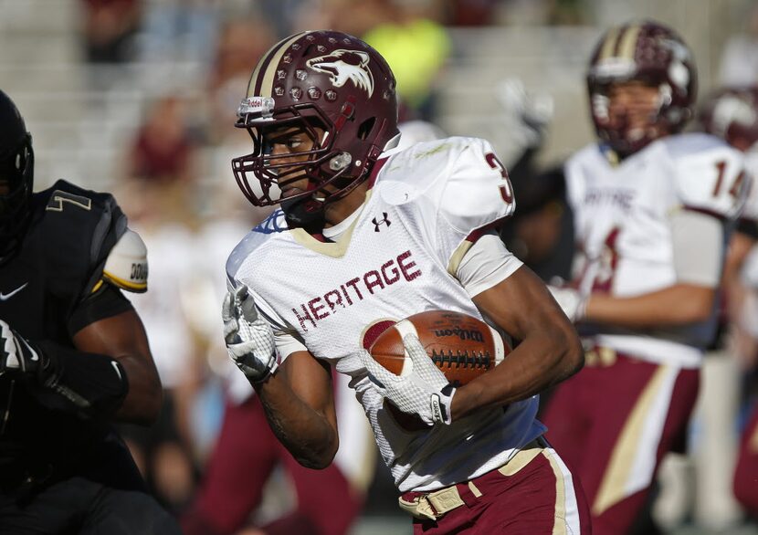 Heritage High School running back Kene Nwangwu (3) carries the football in the first quarter...