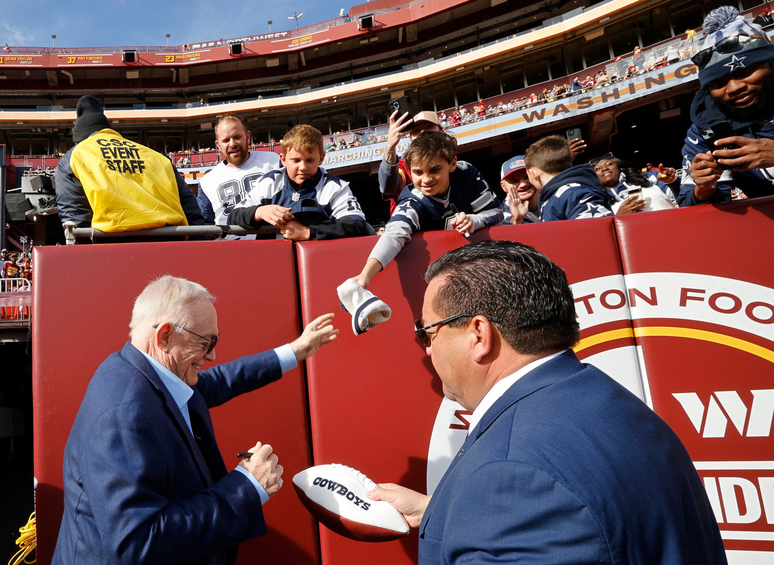 Dallas Cowboys owner Jerry Jones , left, signs autographs for fans before an NFL football...