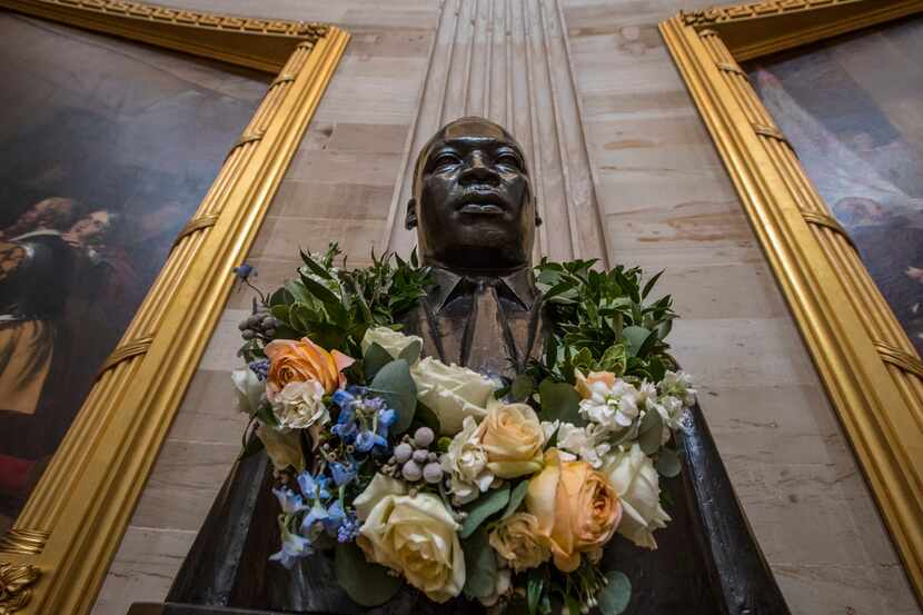The bust of civil rights activist and leader Martin Luther King Jr. is draped with a wreath...