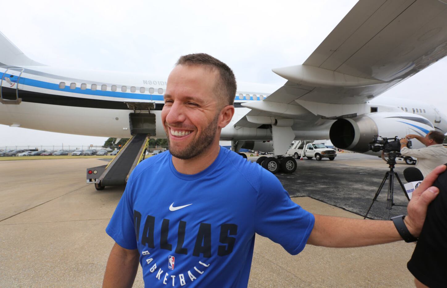 Dallas Mavericks guard J.J. Barea smiles as he helps transfer supplies from a trailer to an...