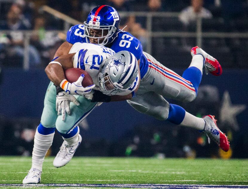 Dallas Cowboys running back Ezekiel Elliott (21) is tackled by New York Giants outside...