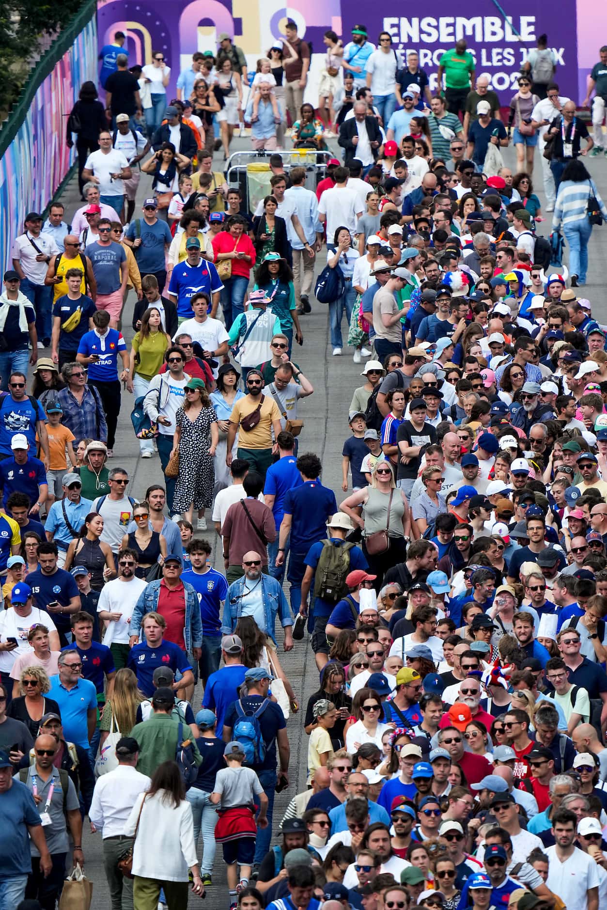 Fans wait in a long line to enter the Stade de France for the opening session of rugby...