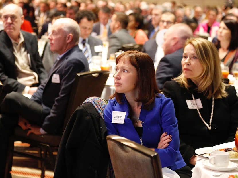 Jessica Trudeau, center, and Paige Conley, right, both with the Momentous Institute, listen...