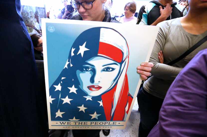 Protesters chanted as they held signs at the international arrivals gate in Terminal D at...