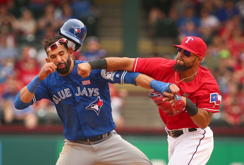 FILE - In this May 15, 2016, file photo, Toronto Blue Jays' Jose Bautista, left, is hit by...