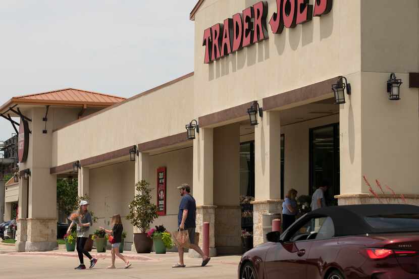 A family walks out of a Trader Joe's grocery store at Pepper Square shopping center in...