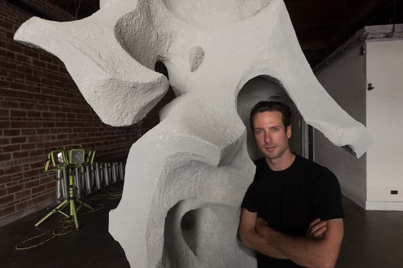 Jason Mehl, a Dallas-based sculptor, poses with one of his unfinished pieces titled...