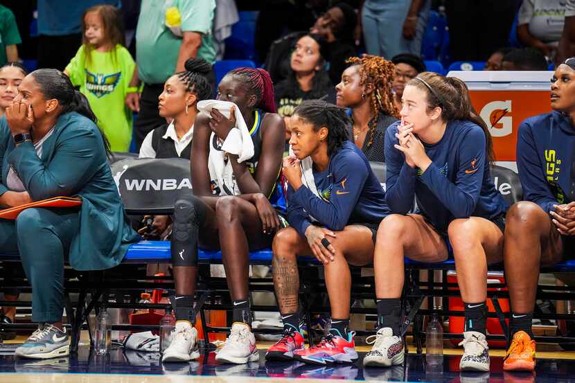 Dallas Wings players look on from the bench during final seconds in Game 3 of a WNBA...