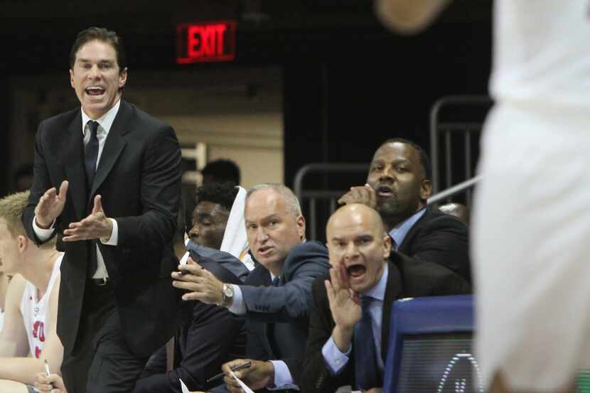 SMU head coach Tim Jankovich gets some help from his assistant coaches in getting a message...