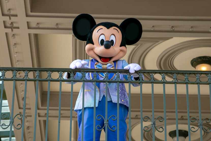 En esta foto de archivo se ve a un actor disfrazado de Mickey Mouse recibiendo a los...