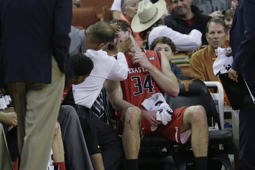 Texas Tech forward Matthew Temple (34) is attended to on the bench after he was injured...