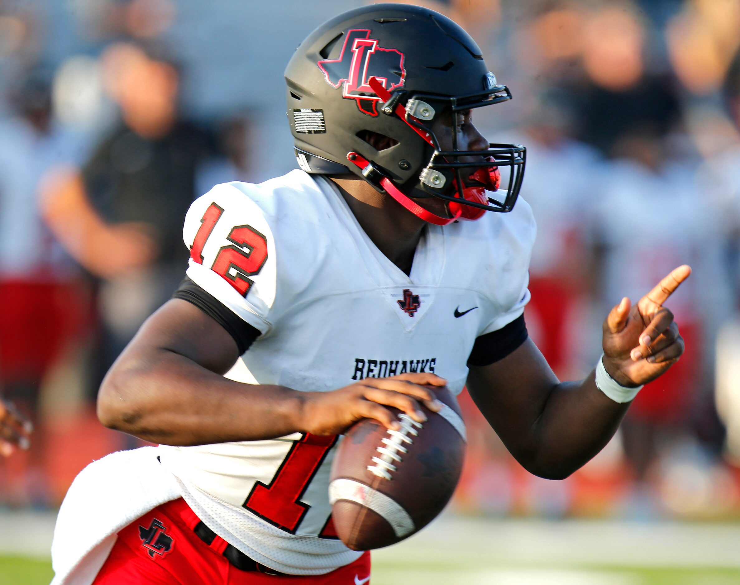 Liberty High School quarterback Keldric Luster (12) rolls out during the first half as Reedy...