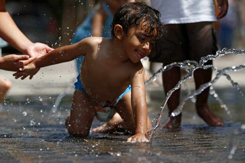 Dylan Davila, 2, of Fort Worth drank from the fountains during Voly in the Park at Klyde...