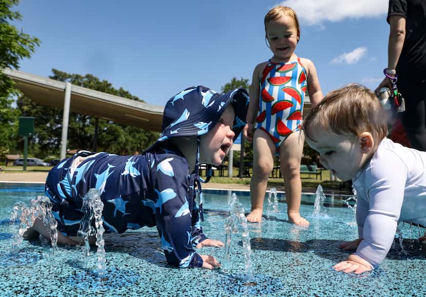 Braelynn Panneck stands between Aiden Panneck and Caleb Gasmire as they play in the water at...