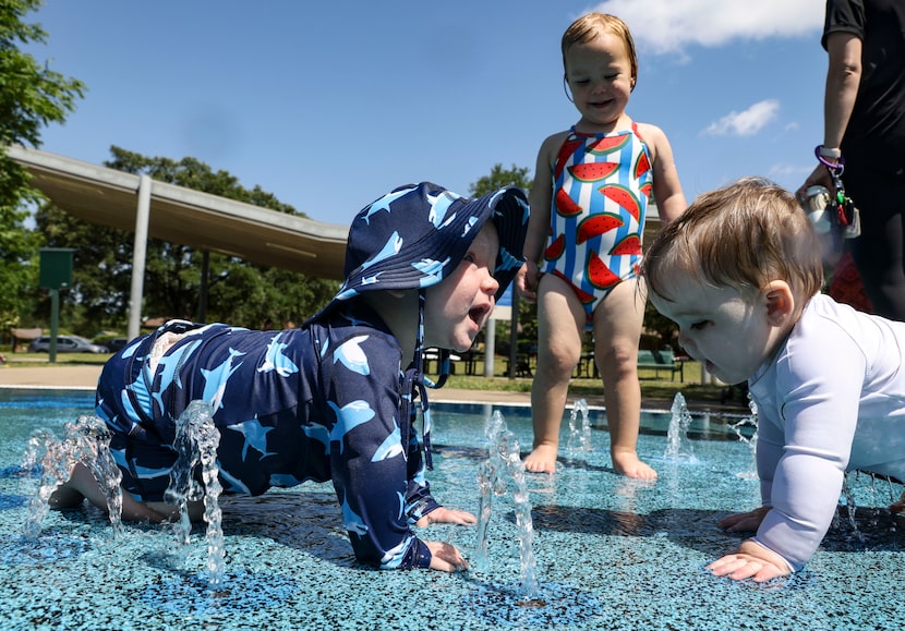 Braelynn Panneck stands between Aiden Panneck and Caleb Gasmire as they play in the water at...