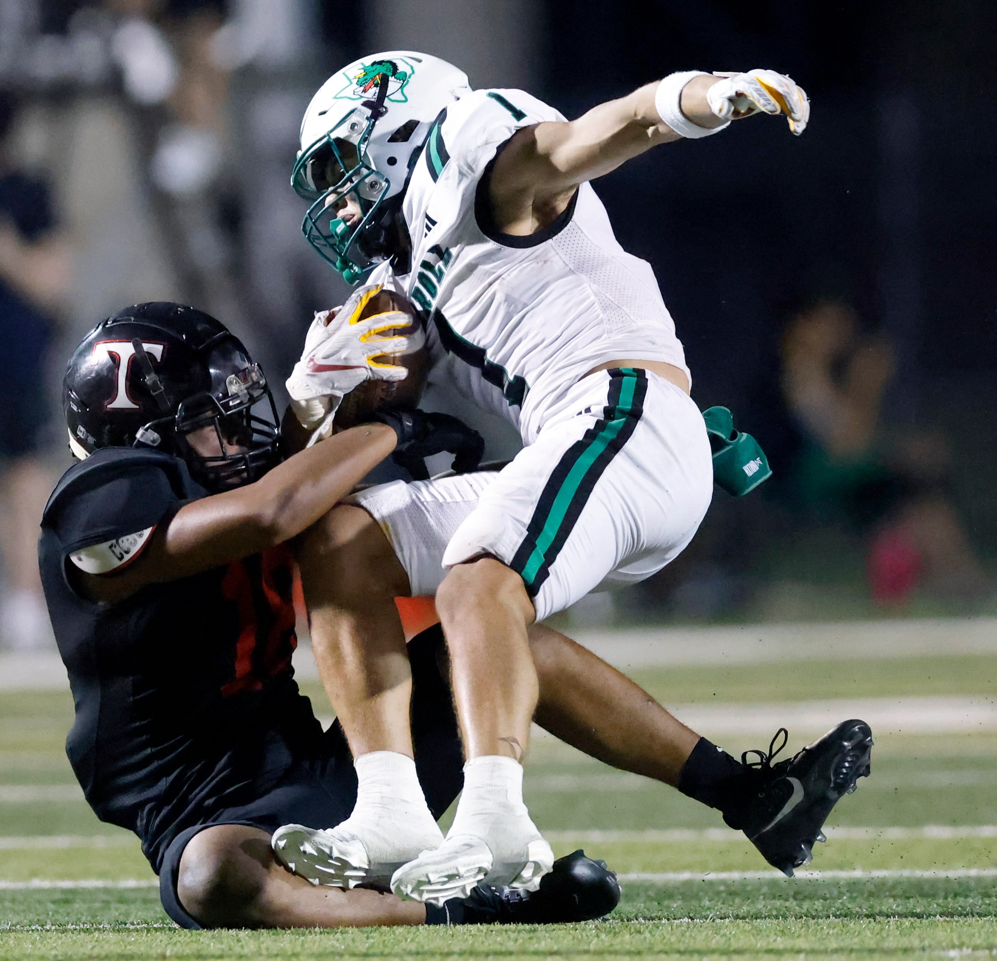 Euless Trinity linebacker Josua Withers (18) tackles Southlake Carroll running back Riley...