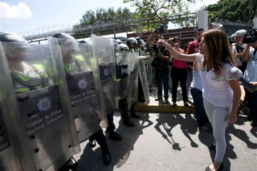 Una estudiante universitaria se enfrenta a la policía durante una protesta exigiendo un...