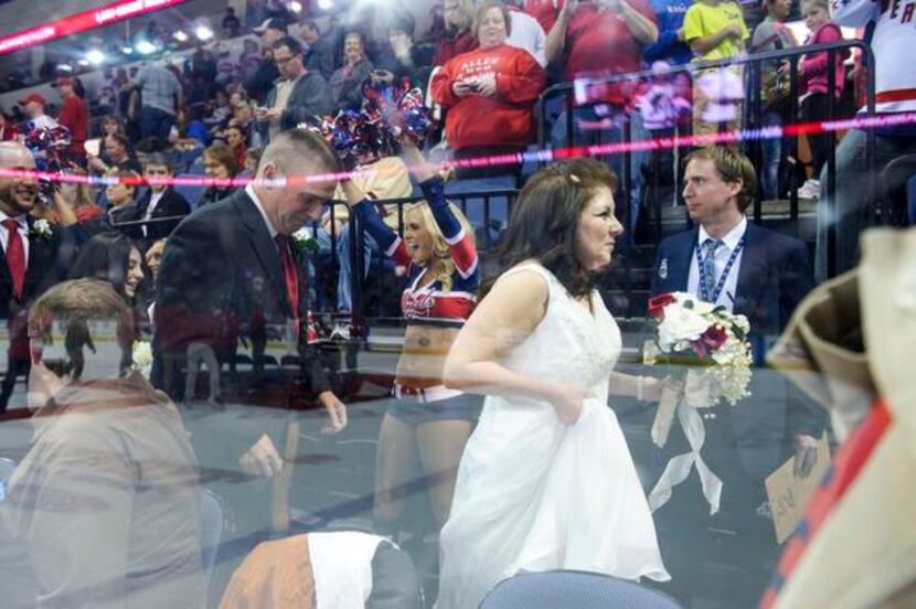 
With the ice reflected in the glass, fans and cheerleaders gave an ovation as Mark and Mary...