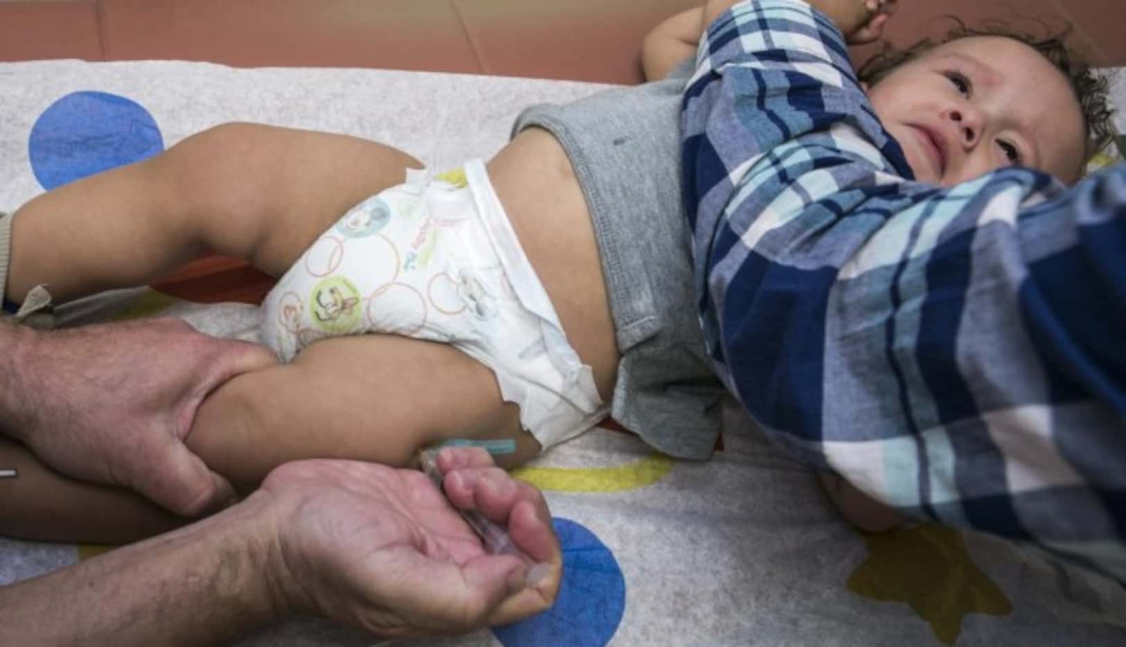 Cameron Fierro, de 1 año, recibe la vacuna MMR contra el sarampión, paperas y rubeóla, en...