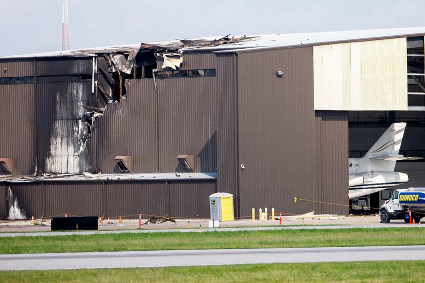 Damage is seen to a hangar after a twin engine plane crashed into the building at Addison...