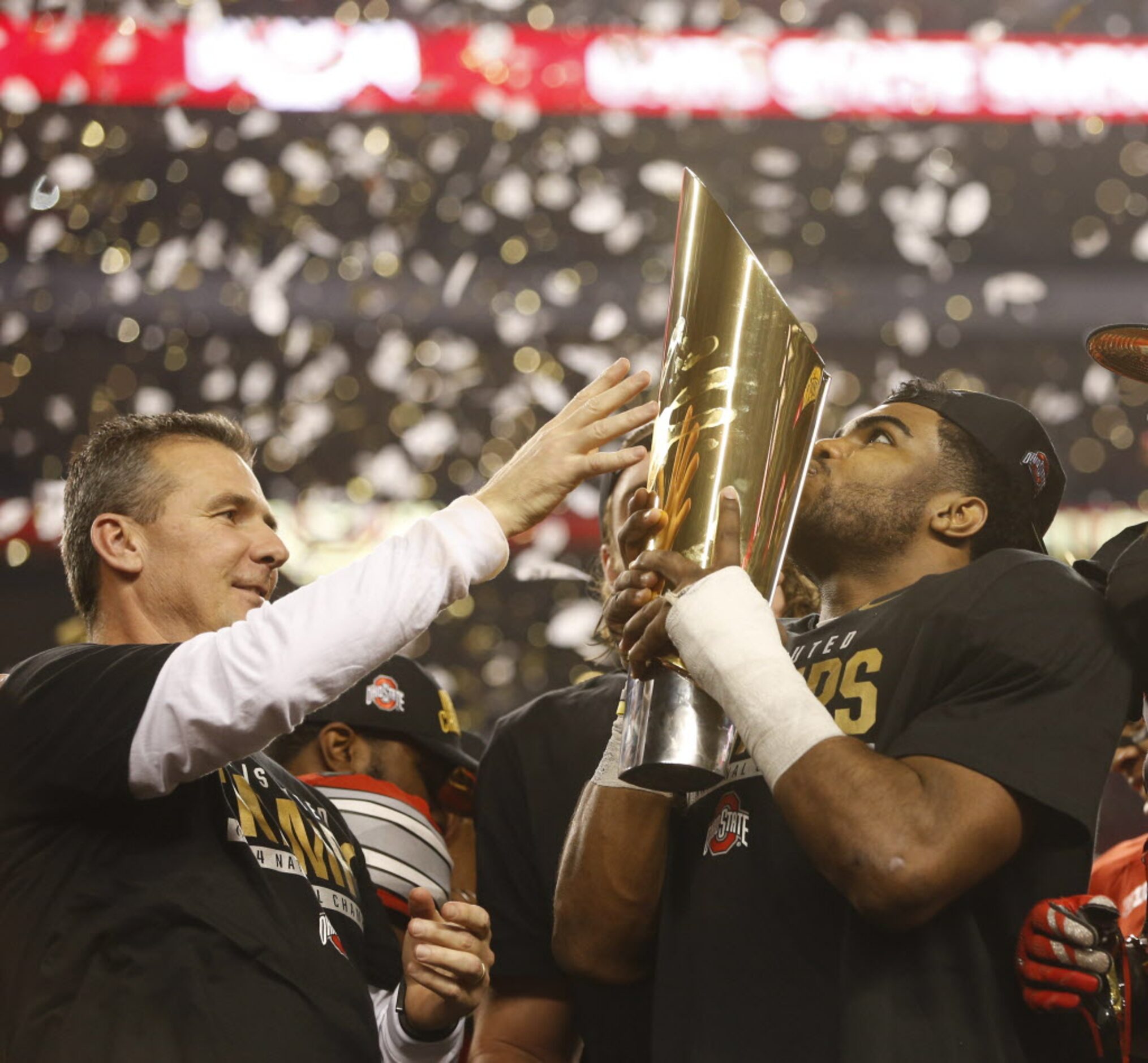 Ohio State Buckeyes head coach Urban Meyer watches as the  championship trophy is kissed by...