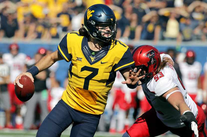 FILE - West Virginia quarterback Will Grier (7) scrambles to avoid a sack by Texas Tech...