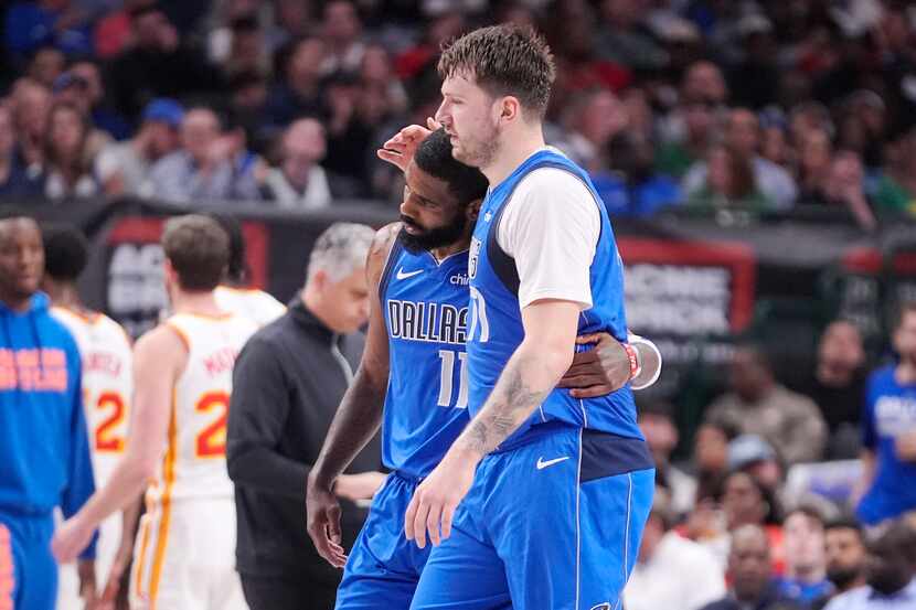 Dallas Mavericks guard Luka Doncic hugs guard Kyrie Irving (11) during the first half of the...