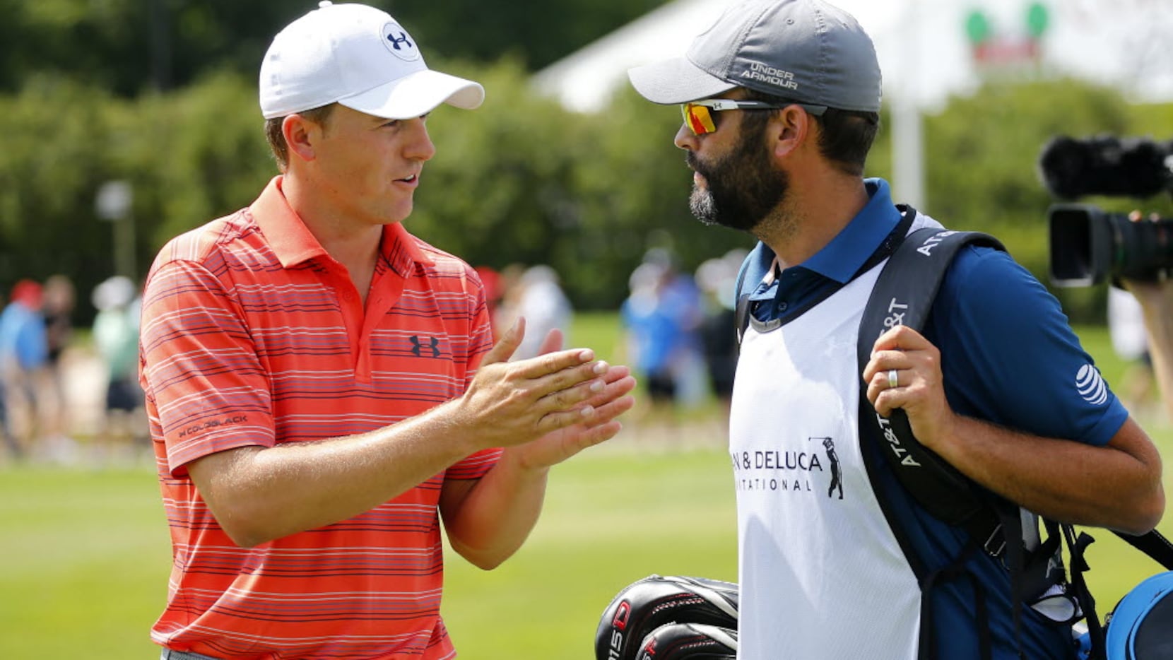 Golfer Jordan Spieth (left) converses with his caddie Michael Greller following his first...
