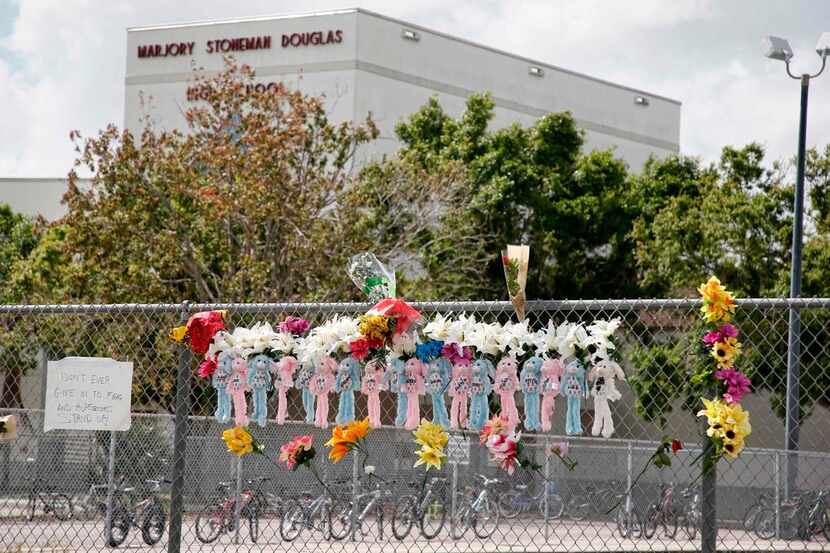 Memorials are seen on a fence surrounding Marjory Stoneman Douglas High School in Parkland,...