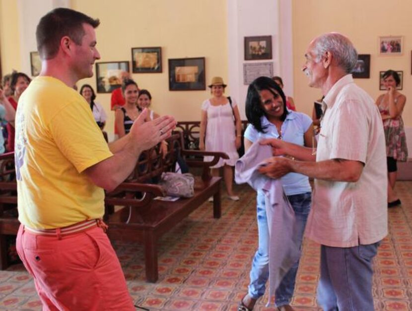 
Credo conductor Jonathan Palant, left, presents a Texas T-shirt to the leader (right) of...