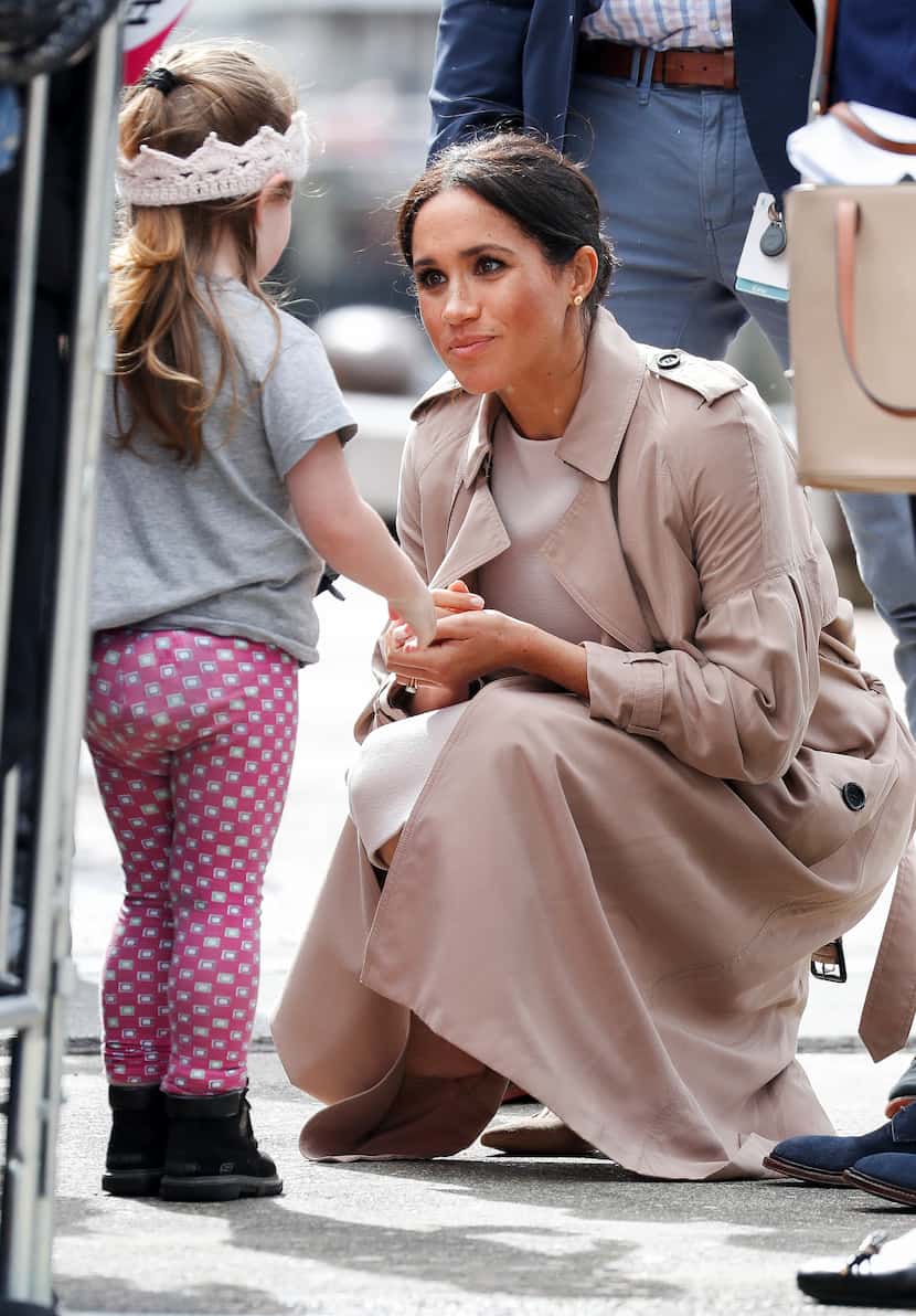 Meghan, Duchess of Sussex talks with a girl during a walkabout at the Viaduct in Auckland,...