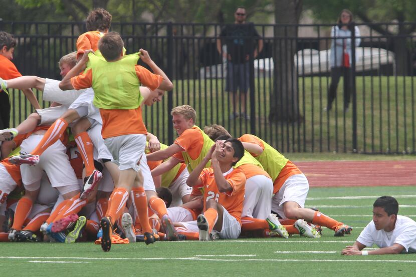 Frisco Wakeland players pile onto the field in celebration after beating Frisco Liberty