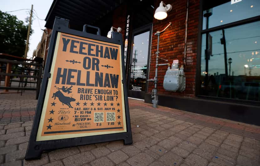 A sign draws people into Punch Bowl Social to ride the mechanical bull in the Deep Ellum...