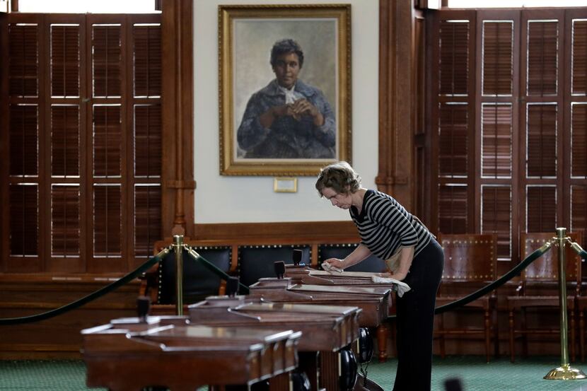 Mara Eurich waxes desks in the Senate Chamber at the Texas Capitol, Wednesday, Jan. 4, 2017,...