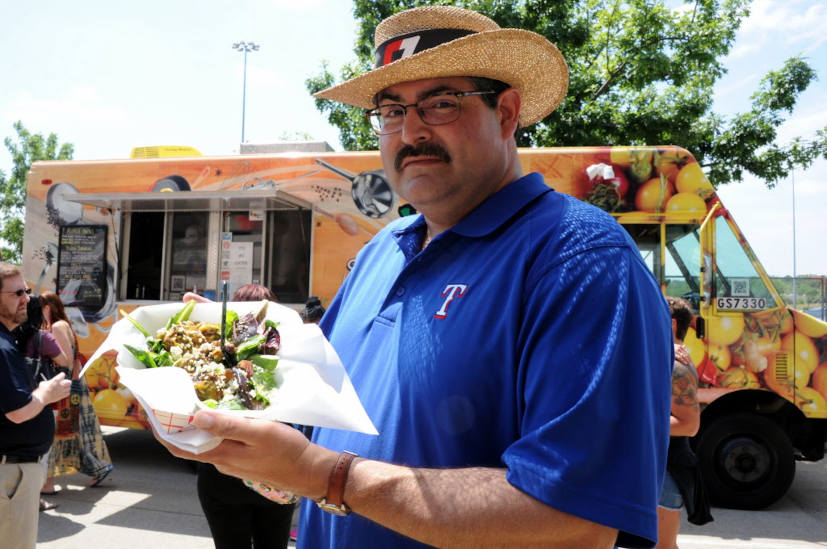 Ben Hernandez from Irving orders pork wings from Yellow Belly at the Food Truck Festival at...